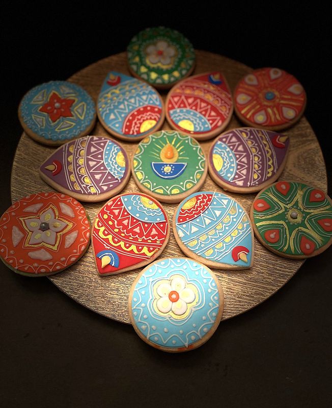 Platter of hand-painted egg-free festival sugar cookies in diya and rangoli designs