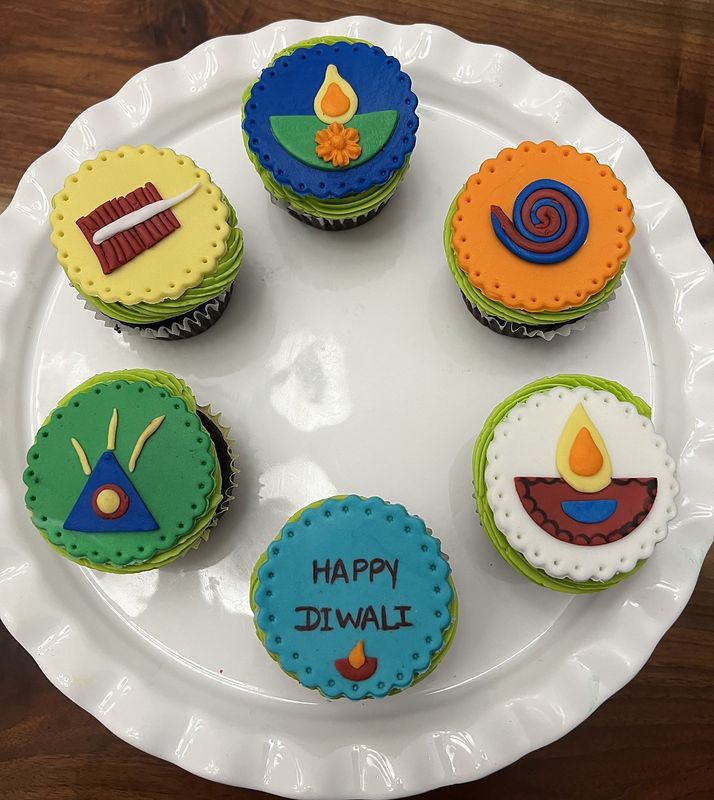 Egg-free Diwali cupcakes topped with fondant diyas, firecrackers and Happy Diwali plaques